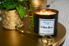 Burning 3 wick Cotton Clean candle with gold wick trimmer on a gold table from illuminate B. Candles